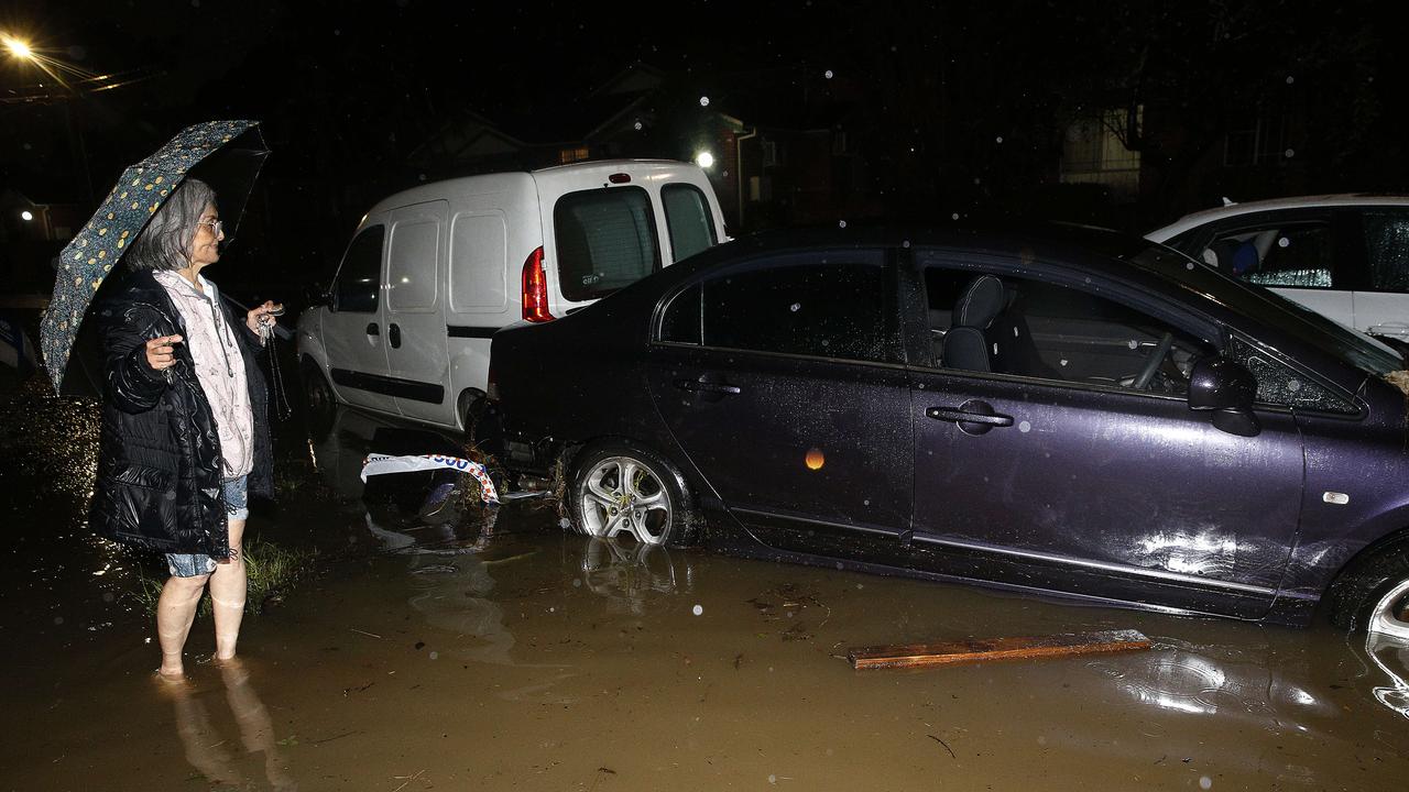 Tho Thi Ngo, 72, next to her car that flood waters carried away into other parked cars. Picture: John Appleyard