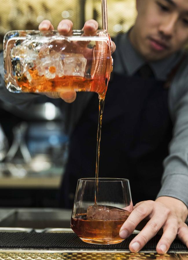 A bartender at Mode Kitchen &amp; Bar serves up a Dusty Negroni.