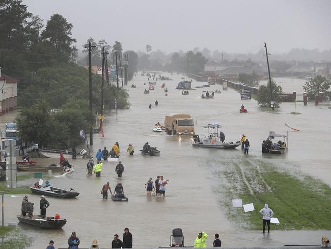 People walk down a flooded street as they evacuate their homes. Picture: Joe Raedle/Getty Images/AFP