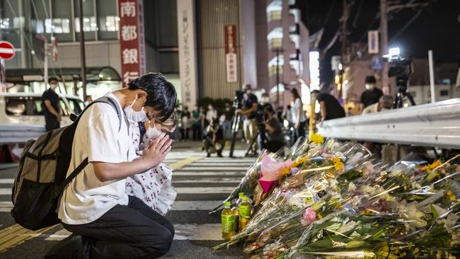 People pray at a site outside of Yamato-Saidaiji Station where Mr Abe was shot.