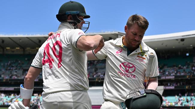 Australiaâs Steve Smith (L) hugs teammate David Warner who walks out after dismissal for the last time in his 112th and farewell Test on day four of the third cricket Test match between Australia and Pakistan at the Sydney Cricket Ground in Sydney on January 6, 2024. (Photo by Saeed KHAN / AFP) / -- IMAGE RESTRICTED TO EDITORIAL USE - STRICTLY NO COMMERCIAL USE --