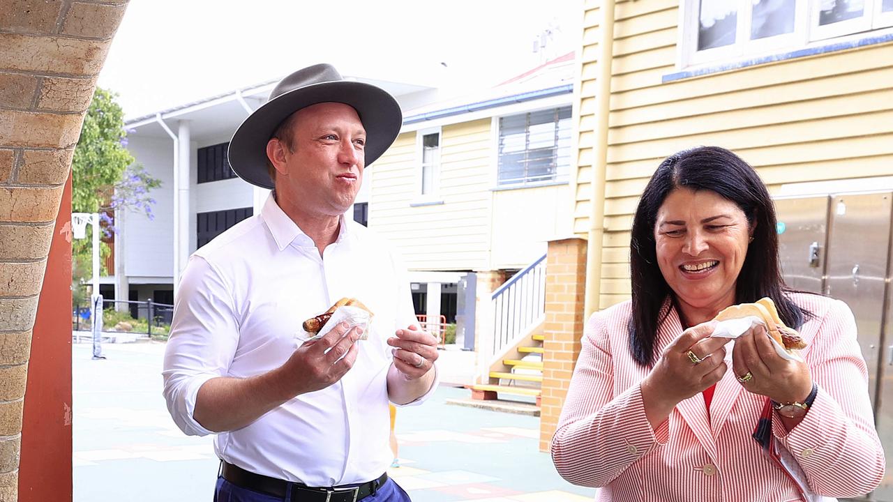 Premier Steven Miles visits the polling booth at New Farm State School and gets stuck into a sausage sandwich with Grace Grace as Election Day gets underway. Pic: Adam Head.