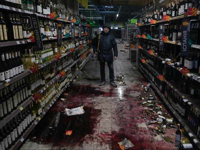 A member of the Ukrainian Territorial Defence Forces stands inside a supermarket, as Russia's invasion of Ukraine continues, in the town of Bucha in the Kyiv region. Picture: Reuters