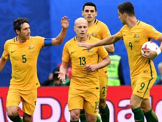 Australia's midfielder Mark Milligan (L) is congratulated by midfielder Aaron Mooy (C) and forward Tomi Juric afetr scoring in a penalty during the 2017 Confederations Cup group B football match between Cameroon and Australia at the Saint Petersburg Stadium on June 22, 2017. / AFP PHOTO / Mladen ANTONOV