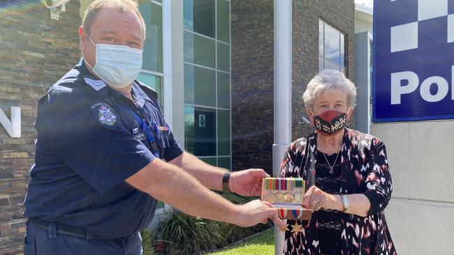Sergeant Vaughan Atherton hands the stolen medals over to Douglas Downs’s sister Rosemary Bowling after 50 years.