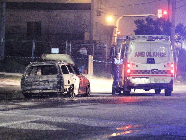 An ambulance at the scene of a car fire in Rosedale st, Greenacre after an alleged carjacking. Picture: Steve Tyson