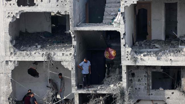 People salvage some belongings from a damaged building following Israeli bombing on Rafah in the southern Gaza Strip, on November 11. Picture: AFP