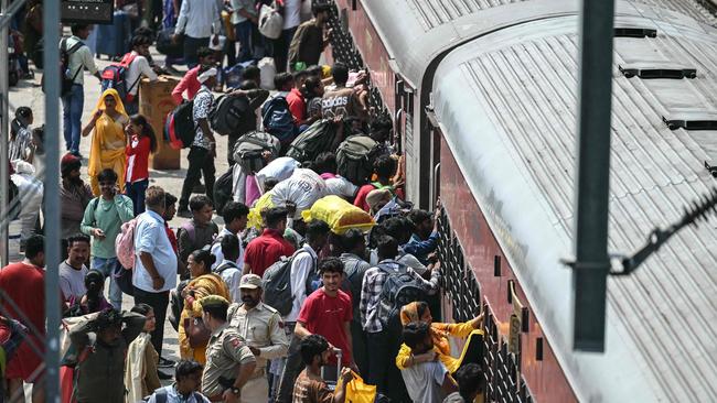 Migrants try to board an overcrowded train at the Jammu Tawi railway station in Jammu on May 10, 2025, amid the ongoing border tensions between India and Pakistan after the Kashmir tourist attack. (Photo by Money SHARMA / AFP)