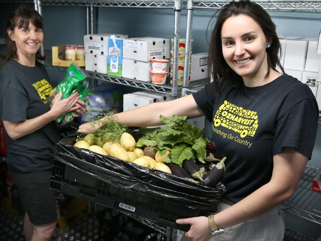Rachel Hibble (R), works as an engagement coordinator for food rescue charity OzHarvest. Her job is to engage with companies to ensure good, surplus food comes to them rather than to landfill and during Covid she jumped into a logistics role as well to make sure food rescue continued. Pictured with colleague Leah Sprigg in the cool room. - The Thanks A Million campaign was launched by News Corp nationally to recognise the everyday Aussies who have been working to keep Australia on track throughout the difficulties of 2020 - bushfires, COVID etc. Rachel Hibble works as an engagement coordinator for food rescue charity OzHarvest. Her job is to engage with companies to ensure good, surplus food comes to them rather than to landfill and during Covid she jumped into a logistics role as well to make sure food rescue continued. 10 November 2020. Picture Dean Martin