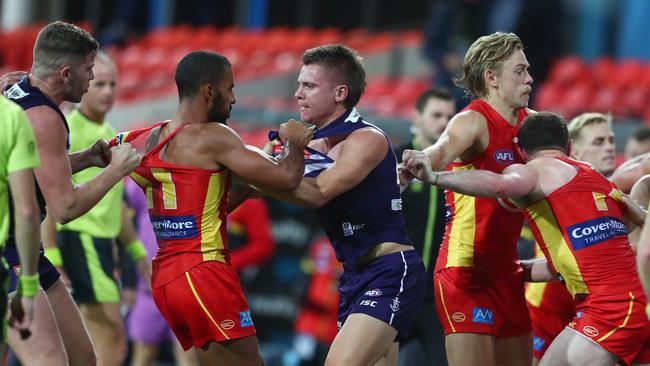 Touk Miller of the Suns and Caleb Serong of the Dockers grapple. Picture: Getty Images