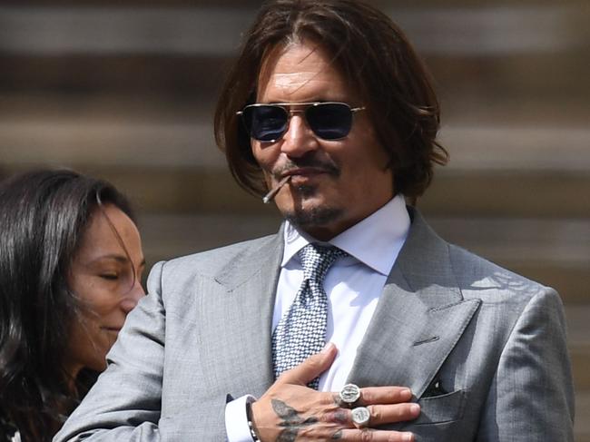 US actor Johnny Depp (C) leaves with members of his team including  lawyer Adam Waldman (2L) after day eight of his libel trial against News Group Newspapers (NGN) at the High Court in London, on July 16, 2020. - Depp is suing the publishers of The Sun and the author of the article for the claims that called him a "wife-beater" in April 2018. (Photo by DANIEL LEAL-OLIVAS / AFP)