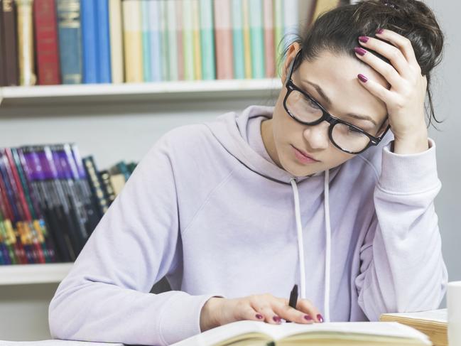 Stressed student  Doing  Homework At The Desk