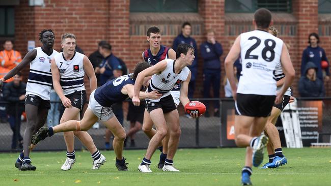 Patrick Dozzi looks to dispose of the ball under pressure. Picture: Steve Tanner