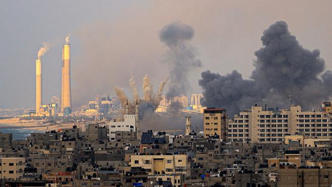 Smoke billows behind high-rise buildings in Gaza City during Israeli air strikes. Picture: Mahmud Hams/AFP