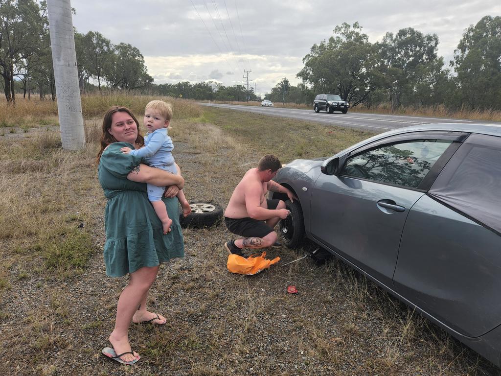 Katrina Worboys with her partner Branden Hellyer and their son Alijah, after blowing a tyre in a massive pothole on the Bruce Highway near Bajool. Photo Darryn Nufer.