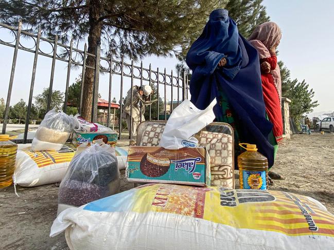 Internally displaced Afghan families wait to received donated food items. Picture: Aseel