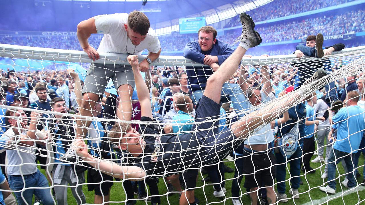 Fans of Manchester City invade the pitch and climb on the goals. Photo by Robbie Jay Barratt – AMA/Getty Images