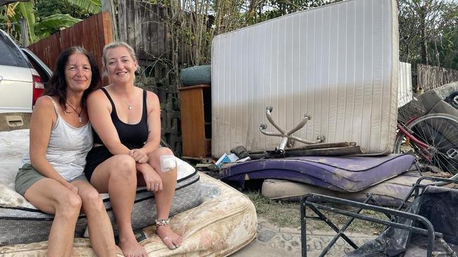 Melissa Hood, pictured with one of her housemates, Kayla Reginato, take a break from the mammoth task of taking flood-damaged household items to the kerb in December. Picture: Bronwyn Farr