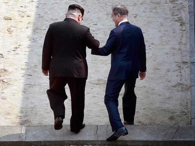 Kim and Moon cross the military demarcation line at the border village of Panmunjom in Demilitarized Zone. Picture: Korea Summit Press Pool via AP