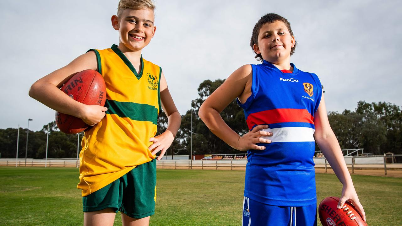 SA Little Legends Riley Graham, 12, from Para Districts, and Micheal-Joshua Lane, 12, from Playford Districts. The smiles on the young opposition players as they show off their colours ahead of the recent School Sport SA Sapsasa State Football Carnival, captures the spirit of competition. This image was taken by news photographer Tom Huntley.