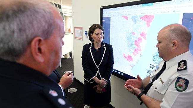 NSW Premier Gladys Berejiklian and NSW Minister for Police and Emergency Services David Elliott are briefed by Commissioner NSW RFS Shane Fitzsimmons in the NSW Rural Fire Service control room in Sydney. Picture: AAP.