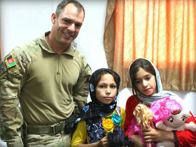 Australian Army Captain Jason Scanes hands out presents to orphaned Afghan children in 2012 or 2013. He often wonders what happened to these children. Picture: Supplied