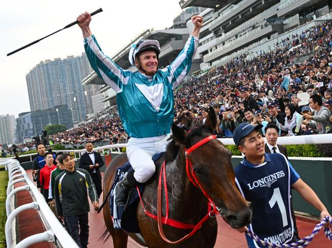 HONG KONG, CHINA - DECEMBER 08: James McDonald riding Romantic Warrior reacts with the crowd after winning Race 8, the Longines Hong Kong Cup during racing at Sha Tin Racecourse on December 08, 2024 in Hong Kong, China.  (Photo by Vince Caligiuri/Getty Images)