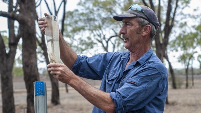 A farmer at Felton near Toowoomba in south-east Queensland, Paul Fuhlbohm, checks a rain gauge after overnight rain. Picture: David Martinelli