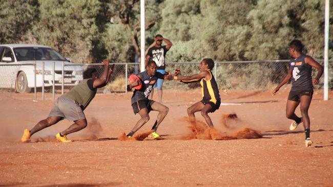 Youngsters kicking up the dirt of the Santa Teresa oval by playing football on it. Picture: SUPPLIED