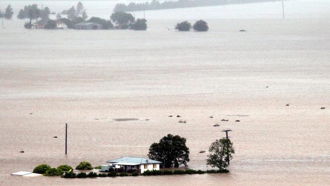 An aerial view of houses and properties surrounded by floodwaters in the Pullenvale area.