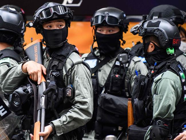 TOPSHOT - Riot police take part in a crowd dispersal operation in the Central district of Hong Kong on May 27, 2020, as the city's legislature debates over a law that bans insulting China's national anthem. - Hong Kong police cast a dragnet around the financial hub's legislature on Wednesday, firing pepper-ball rounds and arresting hundreds as they stamped down on protests against a bill banning insults to China's national anthem. (Photo by ANTHONY WALLACE / AFP)