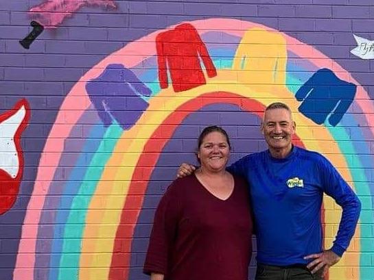 Kasey Millstead and Anthony Field in front of a mural dedicated to Jovi.