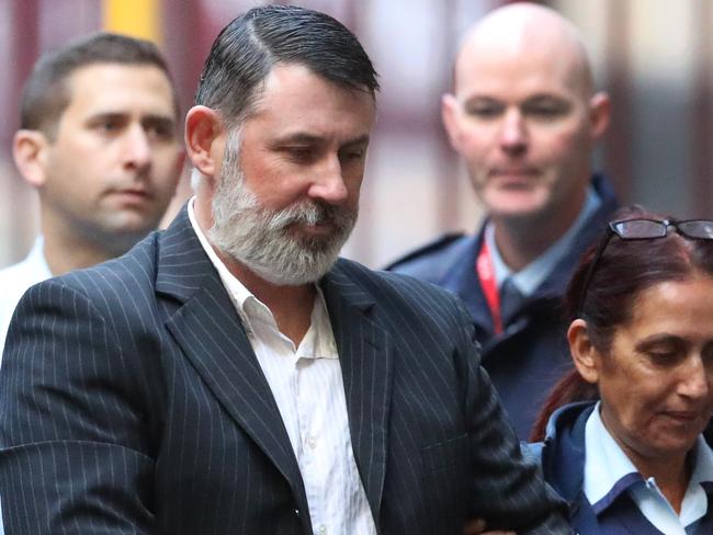 Karl Michael Hague is escorted from a prison van into the Supreme Court of Victoria in Melbourne, Friday, June 15, 2018. He is due to be sentenced after being found guilty in April of killing Ricky Balcombe at Geelong's Market Square shopping centre in May 1995, a crime he got away with for decades. (AAP Image/David Crosling) NO ARCHIVING