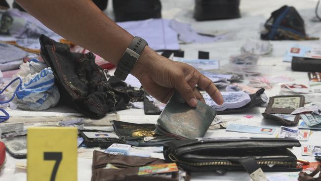 A police officer examines belongings recovered from the Lion Air plane. Picture: AP