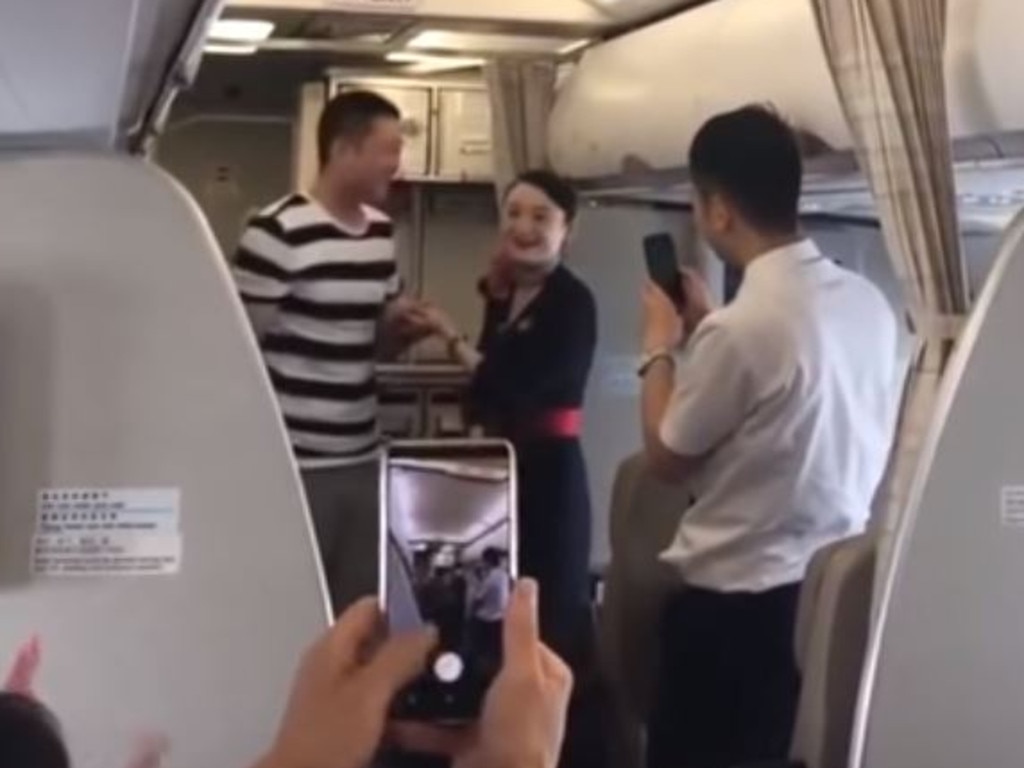 The happy couple deliver the news to cheering passengers. Picture: YouTube