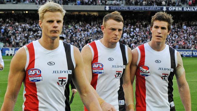 Nick Riewoldt, Brendon Goddard and Lenny Hayes walk off the MCG after the drawn Grand Final.