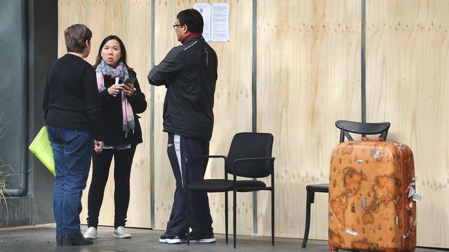 Residents talk to representatives of Mascot Towers before going in to collect their necessary items. Picture: John Feder