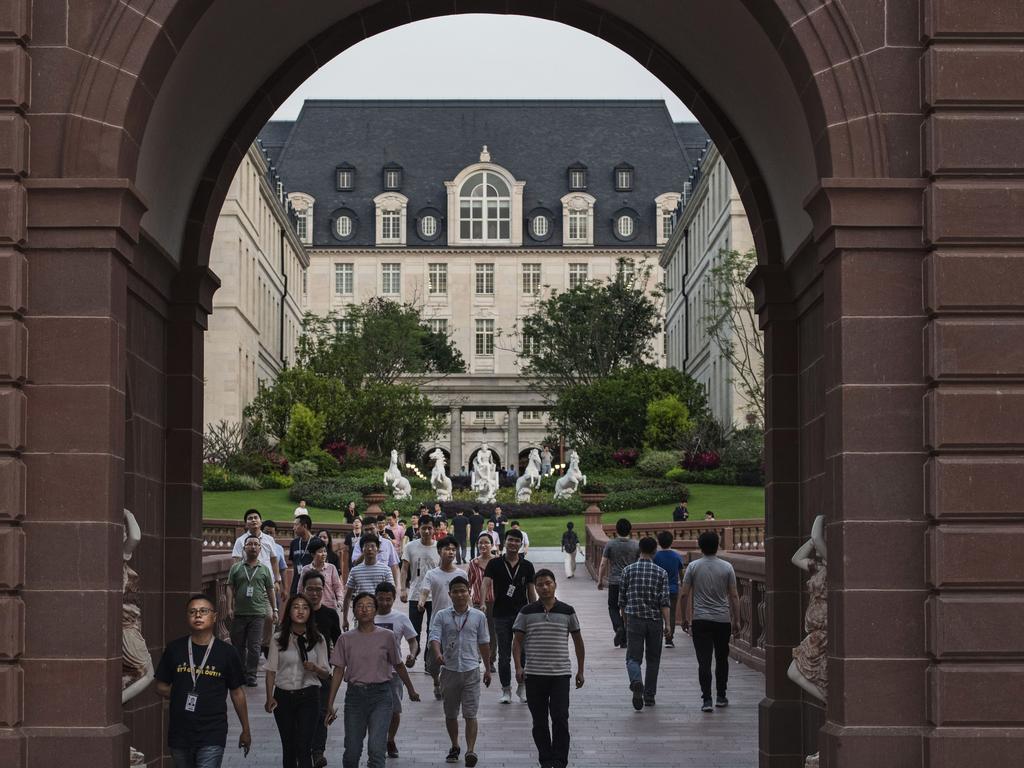 Huawei workers walk together out of the campus at the end of their 12-hour day. Picture: Getty