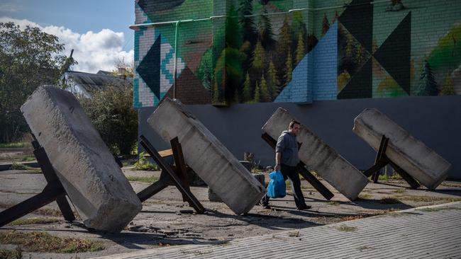 A man walks between anti-tank barriers known as 'hedgehogs' in Bakhmut, Ukraine. Picture: Getty Images