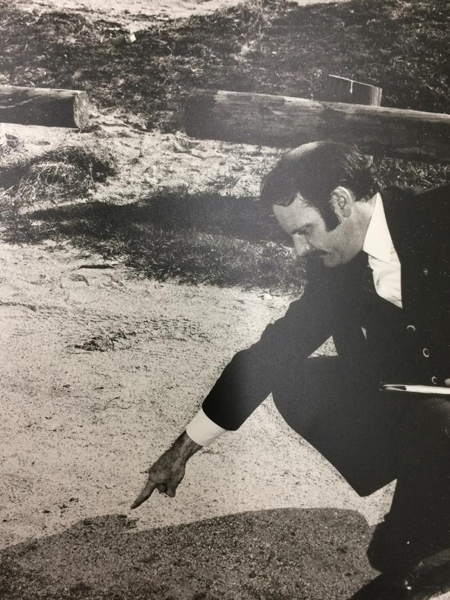 Homicide squad detective Jack Jacobs at the murder scene, pointing to a bullet casing found next to where the first of three shots were fired.