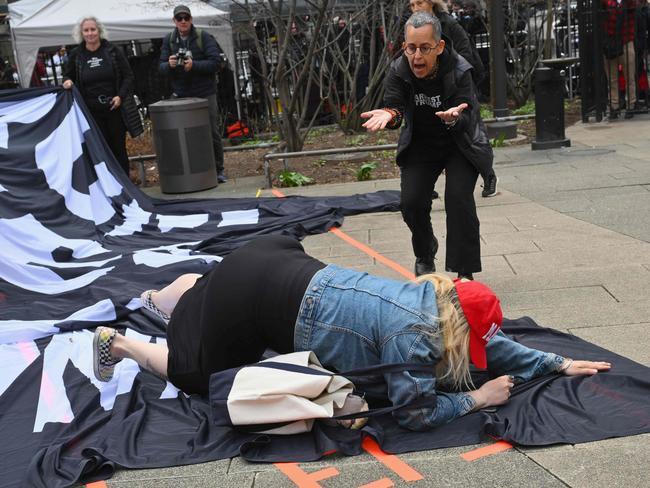 A Trump supporter stumbles as she tried to turn down an anti Trump banner. Picture: AFP