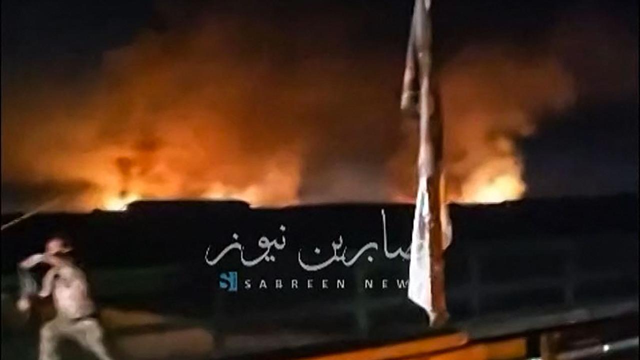 This image grab from a UGC video posted on April 20, 2024, shows fire and smoke rising in the central province of Babylon after an alleged bombing overnight on an Iraqi military base housing a coalition of pro-Iranian armed groups. The explosion hit the Kalsu military base in Babylon province south of Baghdad, where Iraq's Popular Mobilization Forces, or Hashed al-Shaabi, is stationed, according to an interior ministry source and a military official. (Photo by UGC / AFP) / - NO Resale - NO Internet / / XGTY / XGTY/RESTRICTED TO EDITORIAL USE - MANDATORY CREDIT AFP -  SOURCE: SABREEN NEWS - NO MARKETING - NO ADVERTISING CAMPAIGNS -  DISTRIBUTED AS A SERVICE TO CLIENTS - NO ARCHIVE - AFP IS NOT RESPONSIBLE FOR ANY DIGITAL ALTERATIONS TO THE PICTURE'S EDITORIAL CONTENT -NO USE 10 DAYS AFTER VALIDATION - / BEST QUALITY AVAILABLE