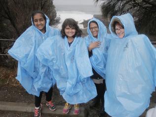 Bhabika Tendun, left, Tenika Sharma, Angu Tendun, Sandra Sharma try to stay dry at the Blowhole on the Tasman Peninsula. Picture: MATT THOMPSON