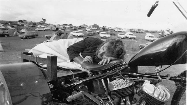 Music fan John Collins of Ipswich, Qld, caught napping on his 1942 Harley-Davidson trike after a hectic night at Ponde rock music festival, held by the Hell's Angels Motorcycle Club in Ponde near Mannum, SA, 23 Feb 1992.