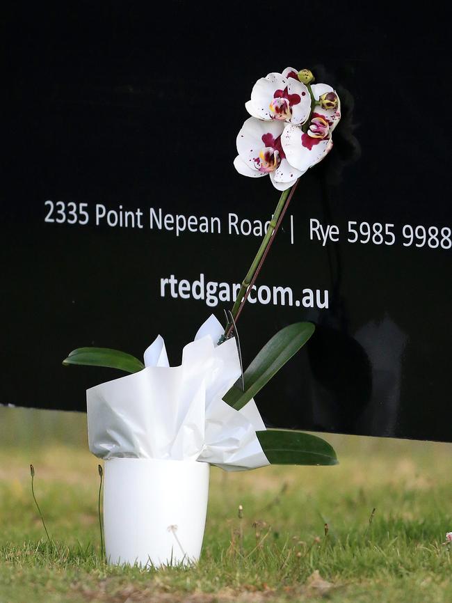 Two women leave flowers at the scene. Picture: Mark Stewart