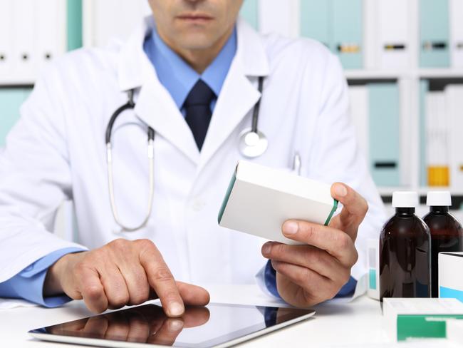 Doctor reading a Digital Tablet with drug boxes in hand  at Office Desktop. Health care, Medical and Pharmacy Concept.