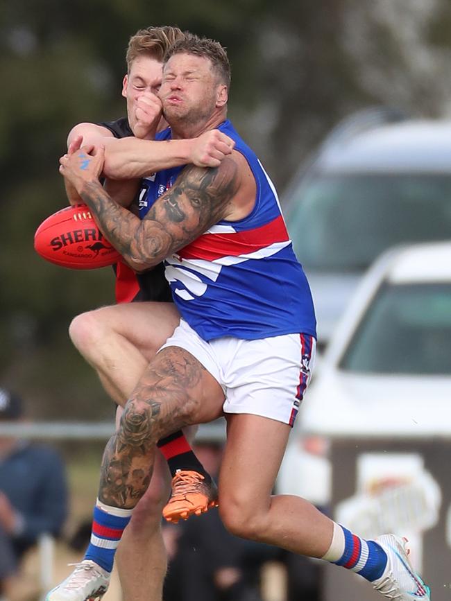 Waaia coach Mitch Cleeland and Strathmerton’s Jake Anderson compete hard for the ball.