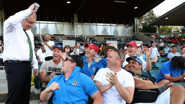 PM Scott Morrison skolls a beer after a group of men challenge him to do a hawkie at the PMÕs XI cricket match. Picture: Kym Smith