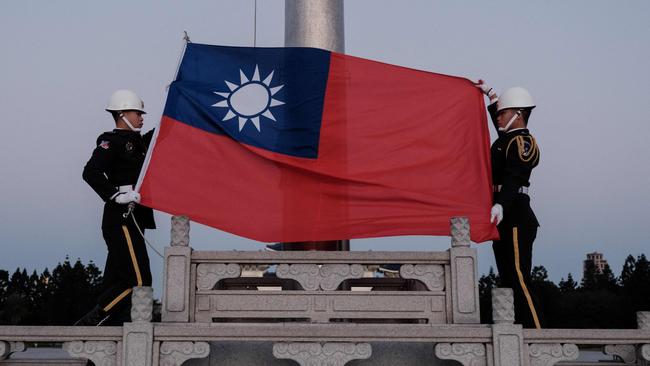 Guards raise Taiwan's national flag on the Democracy Boulevard at the Chiang Kai-shek Memorial Hall in Taipei.