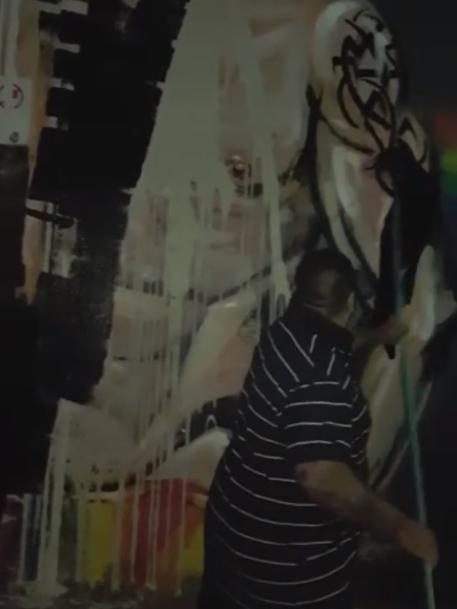 A man is seen painting over the mural.